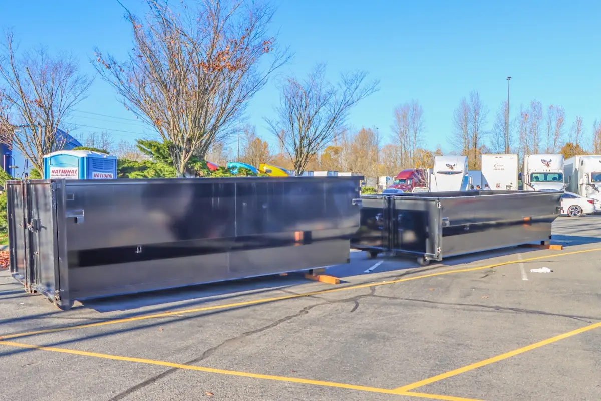 Professional dumpster rental service with roll-off container on residential driveway in Winchester